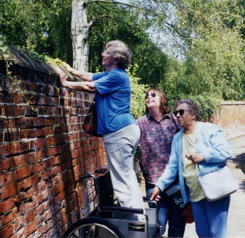 Former land girl Irene Grimwood looking over the wall at the Halesworth rectory