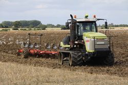 Claas Challenger 75E pulling a 10-furrow plough